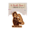 Wooden pin with 'We Can Do It!' slogan on a grid background with floral pattern