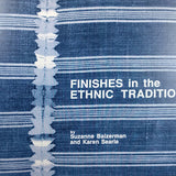Cover of the book- the background is an indigo and white striped woven tapestry with embroidery along a seam. The title of the book, "Finishes in the Ethnic Tradition" and the authors, "by Suzanne Baizerman and Karen Searle" in white text 