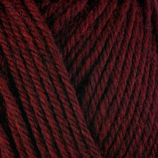 Detailed view of a skein of superwash wool yarn, showcasing a deep red hue.