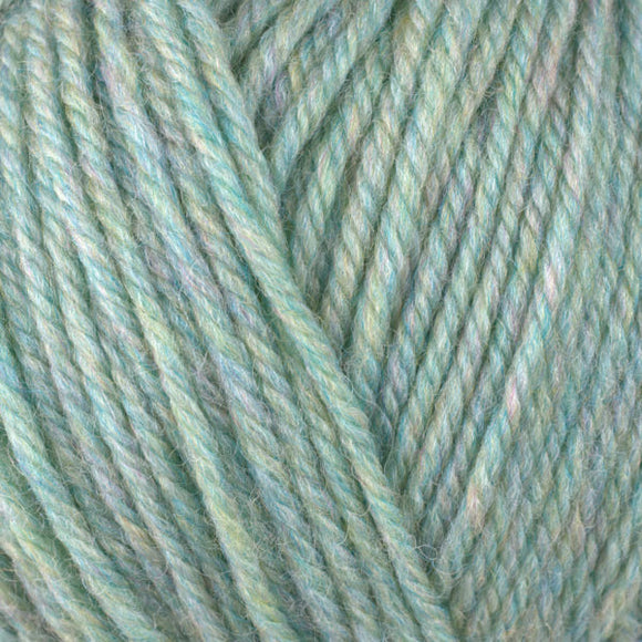 Detailed view of a skein of superwash wool yarn, showcasing a green hue.
