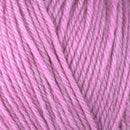 Detailed view of a skein of superwash wool yarn, showcasing a pink hue.