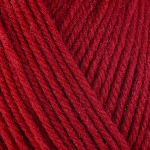 Detailed view of a skein of superwash wool yarn, showcasing a red hue.