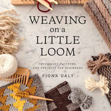 Book cover of 'Weaving on a Little Loom' by Fiona Daly with weaving materials on a marble surface.