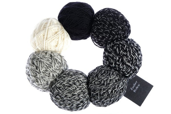 A black and white set of Schoppel Zauber Perlen yarn balls