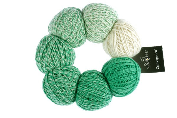 A white and green set of Schoppel Zauber Perlen yarn balls