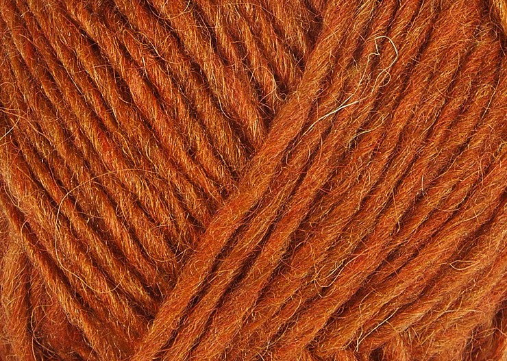 A close up photo of orange Istex Lettlopi yarn