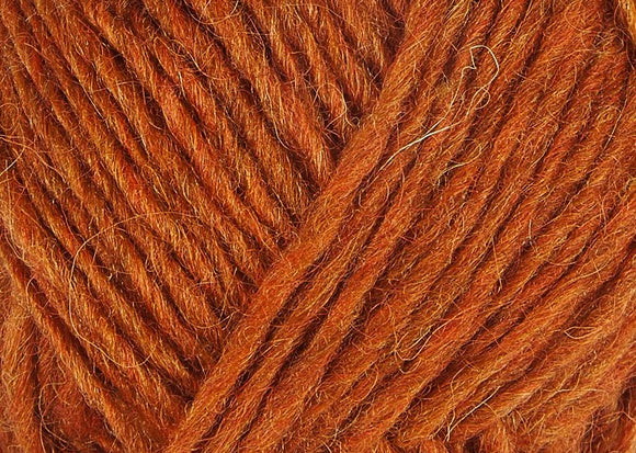 A close up photo of orange Istex Lettlopi yarn