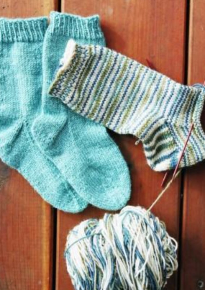 A pair of knitted socks on knitting needles