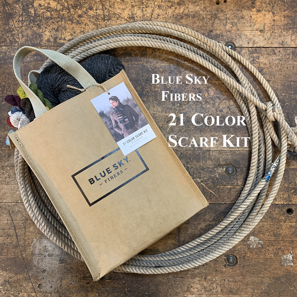 A photo of the Blue Sky Fibers Woolstok yarn scarf kit in a lasso on a wooden surface