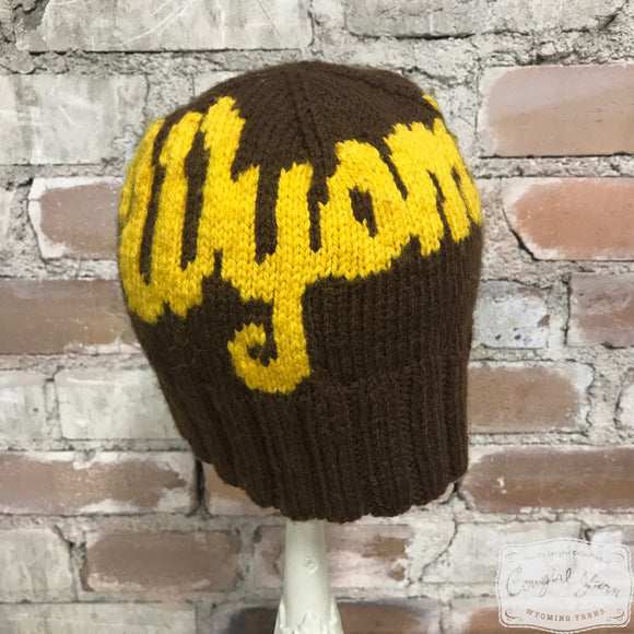 A brown and gold beanie hat with buttons that says Wyoming 