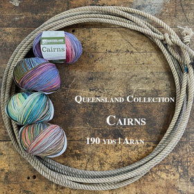 Multiple skeins of various colors inside a lasso on a wooden surface