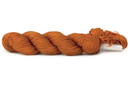 A photo of a pumpkin colored hank of CoBaSi sock yarn.