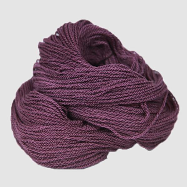 A wine colored hank of the Mountain Meadow Wool Saratoga yarn collection
