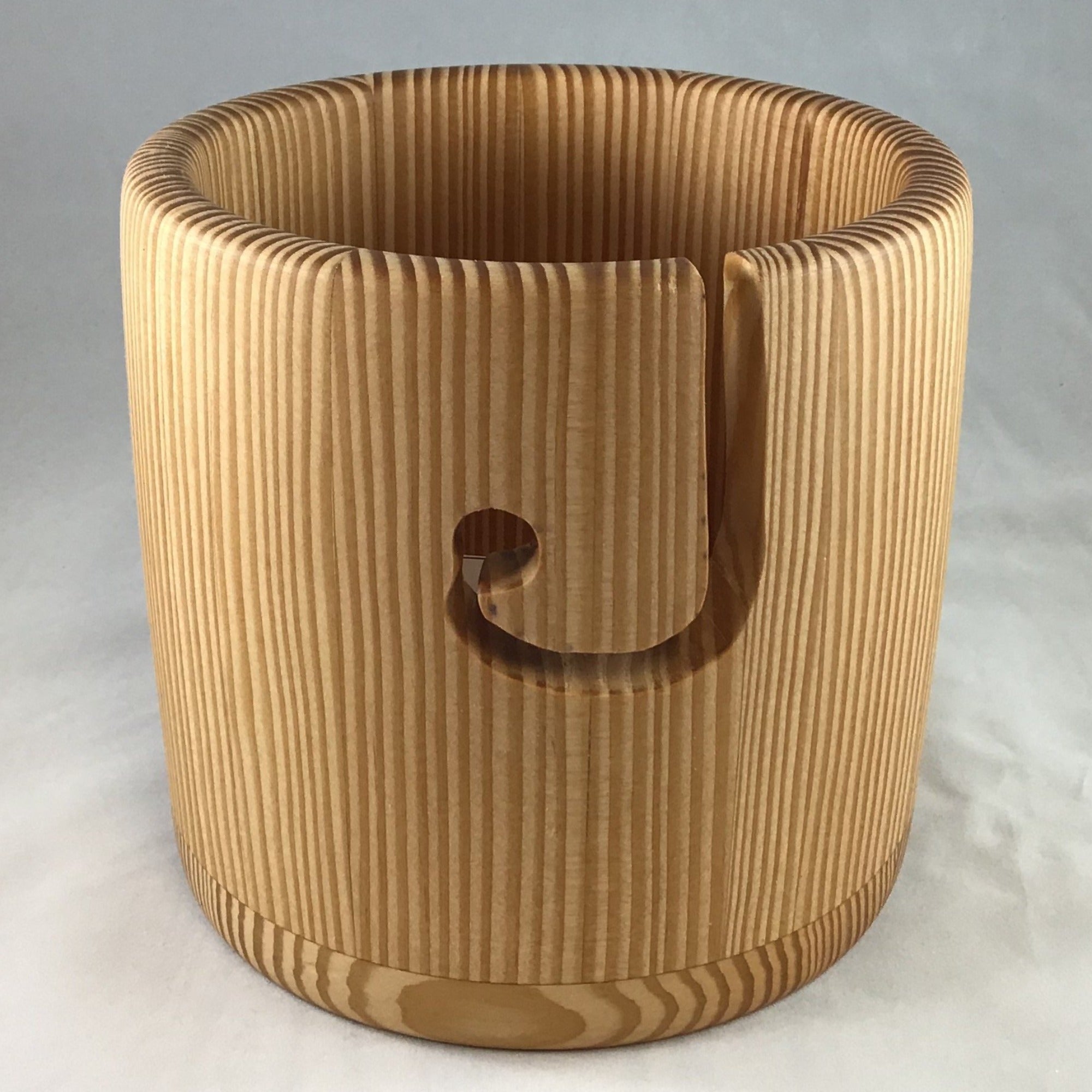  A wooden yarn bowl made from Douglas Fir wood against a white backdrop