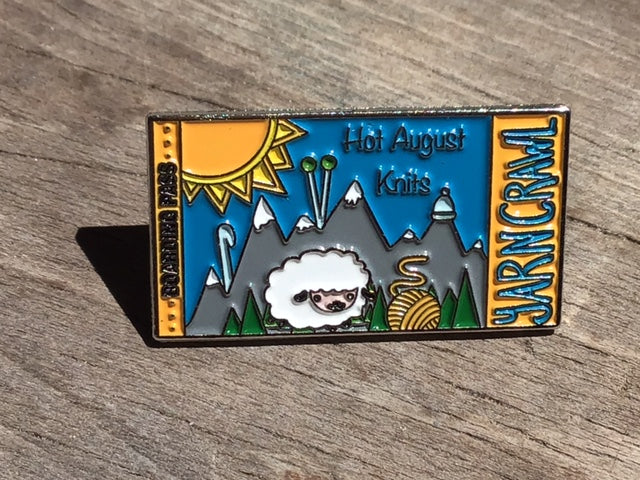 Hot August Knits Yarn Crawl pin for 2022. An enamel pin featuring the HAK logo with a sheep in front of the mountains.