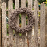 Knitted wreath on wooden gate