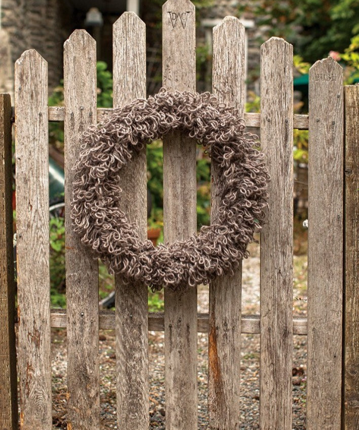 Knitted wreath on wooden gate