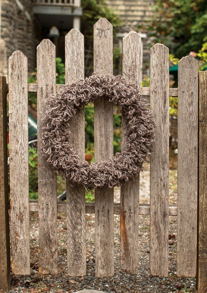 Knitted wreath on wooden gate