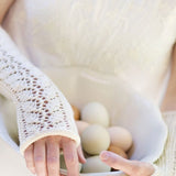 Woman wearing fingerless mitts holding eggs