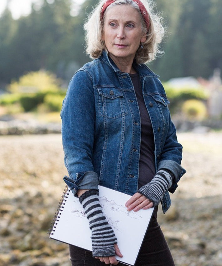 A woman wearing knitted fingerless gloves