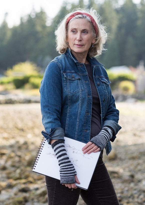 A woman wearing knitted fingerless gloves