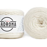 A photo of two white cakes of HiKoo Madrona yarn
