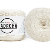 A photo of two white cakes of HiKoo Madrona yarn