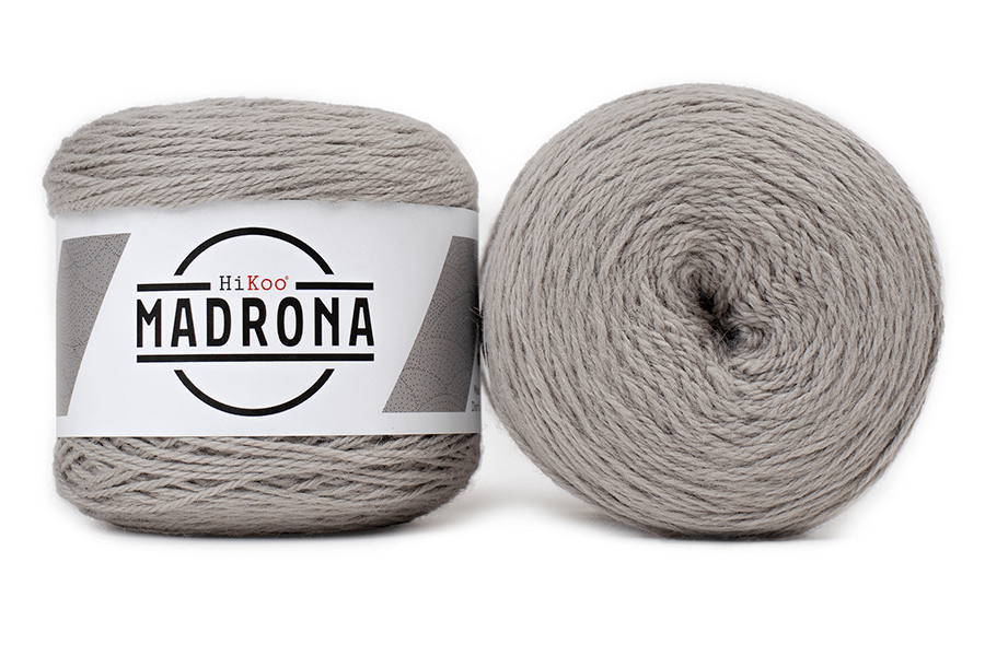 A photo of two gray cakes of HiKoo Madrona yarn