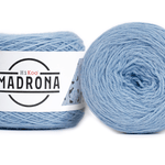 A photo of two light blue cakes of HiKoo Madrona yarn