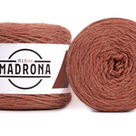 A photo of two orange cakes of HiKoo Madrona yarn
