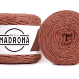 A photo of two orange cakes of HiKoo Madrona yarn