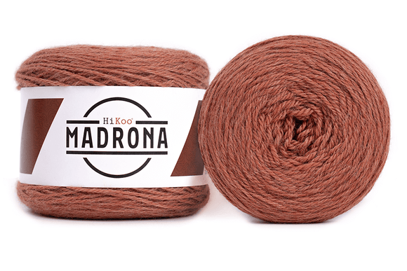 A photo of two orange cakes of HiKoo Madrona yarn