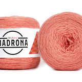 A photo of two salmon colored cakes of HiKoo Madrona yarn
