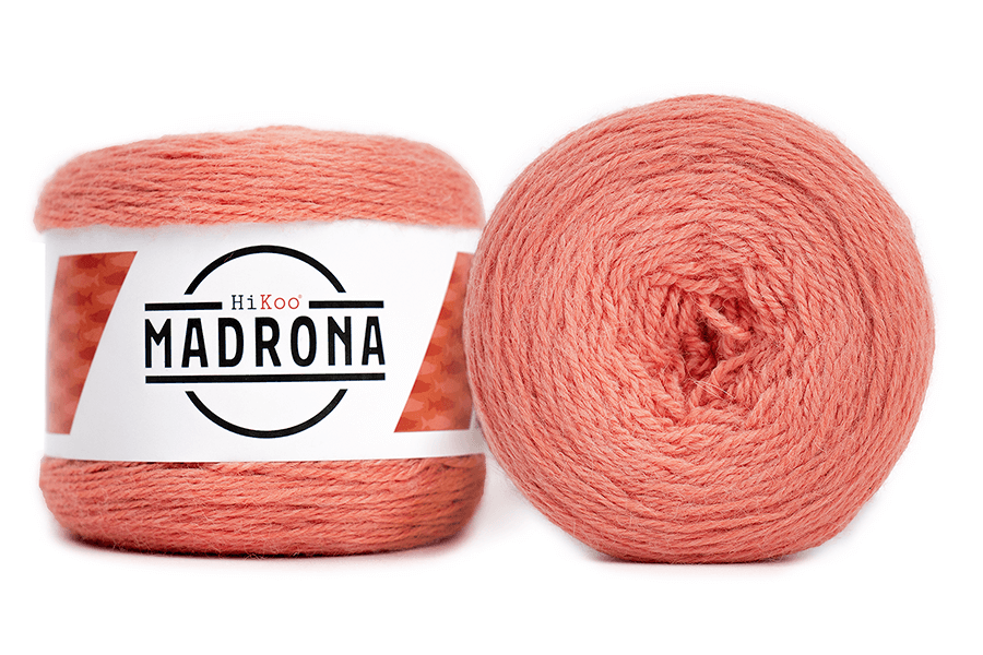 A photo of two salmon colored cakes of HiKoo Madrona yarn