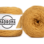 A photo of two yellow cakes of HiKoo Madrona yarn