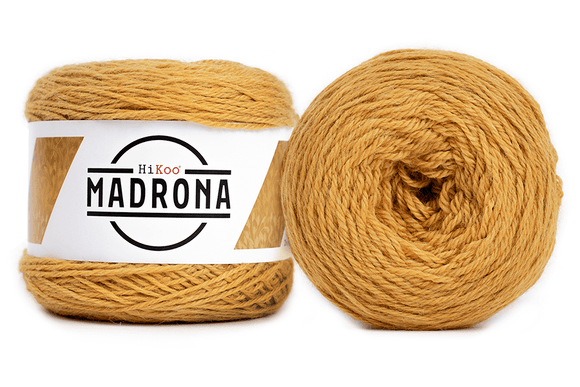 A photo of two yellow cakes of HiKoo Madrona yarn