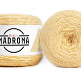 A photo of two light yellow cakes of HiKoo Madrona yarn