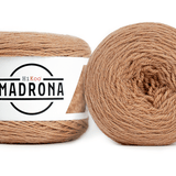 A photo of two light brown cakes of HiKoo Madrona yarn