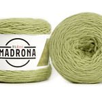 A photo of two light green cakes of HiKoo Madrona yarn