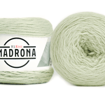 A photo of two light green cakes of HiKoo Madrona yarn