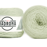 A photo of two light green cakes of HiKoo Madrona yarn