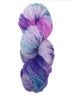Hank  of the colorway Kiowa- variegated purple with speckles of bright blue and streaks of pink.