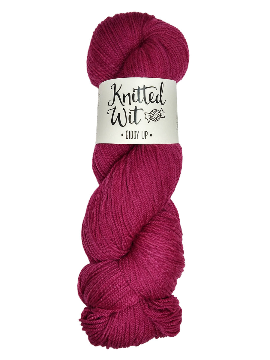 A colorful dark pink hank of Knitted Wit's Giddy Up Yarn