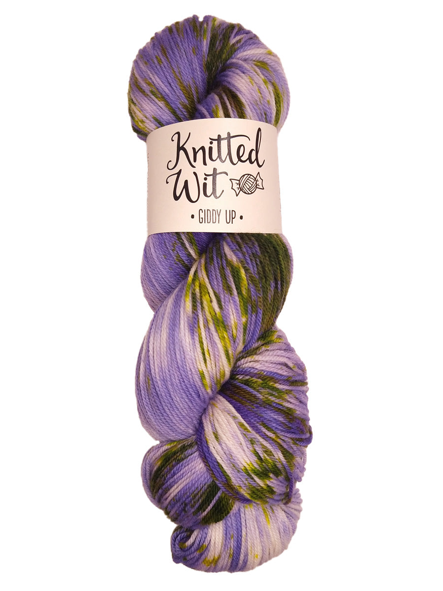 A colorful purple and green hank of Knitted Wit's Giddy Up Yarn