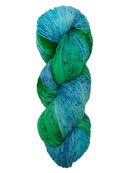 Hank of the colorway Scout- variegated blue and green with speckles of dark blue and dark green.