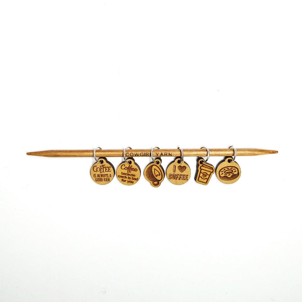 A photo of six stitch markers related to coffee.