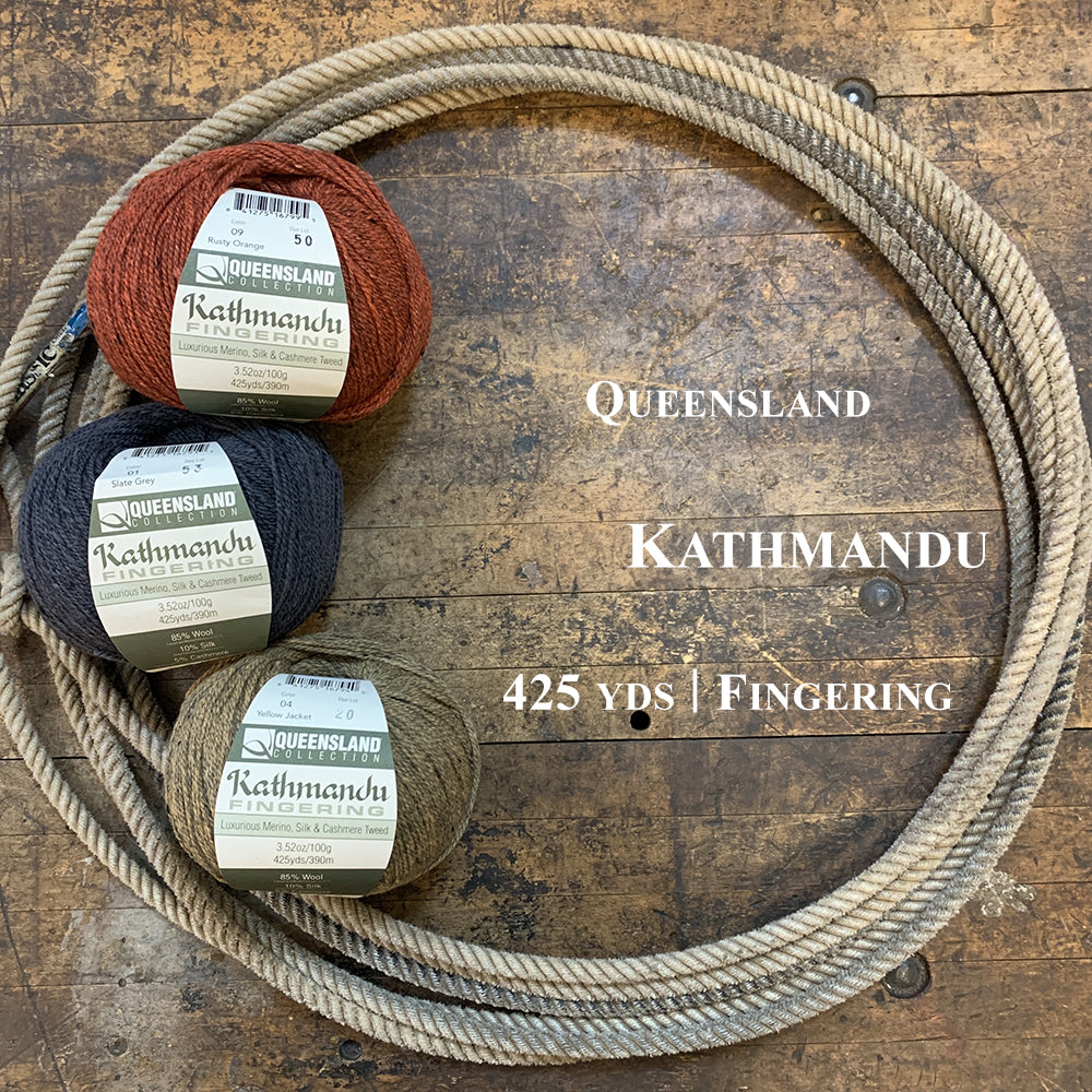 A photo of three balls of Kathmandu yarn in a lasso on a wooden surface