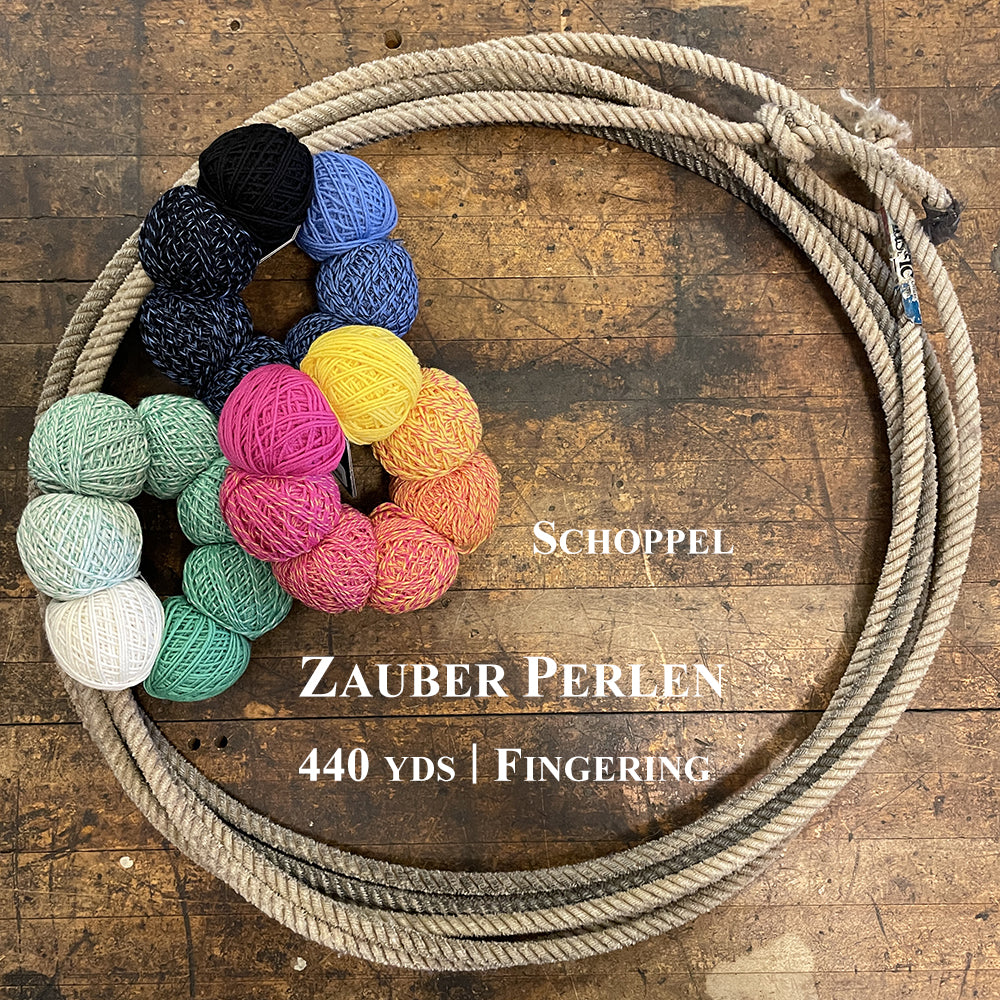 Three colorful sets of Schoppel Zauber Perlen in a lasso on a wooden surface