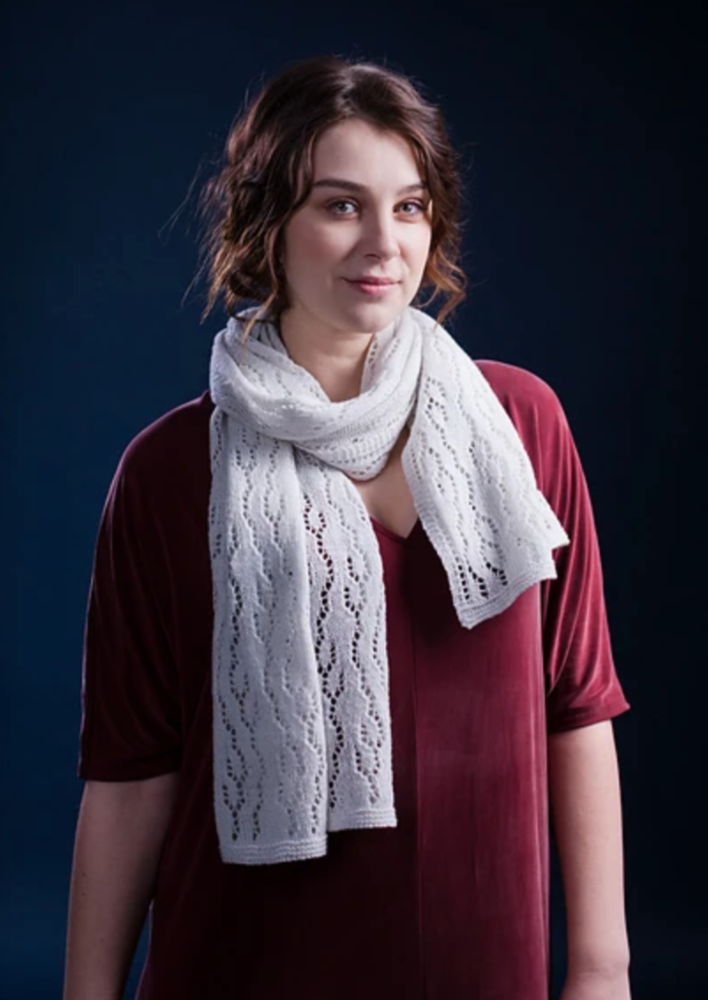 A woman wearing a white, knitted shawl
