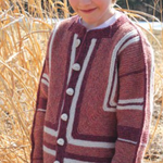 A young girl wearing a knitted jacket